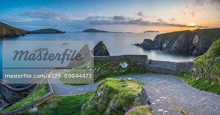Dunquin pier (Dún Chaoin), Dingle peninsula, County Kerry, Munster province, Ireland, Europe. Panoramic view of the trail at sunset.