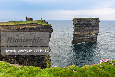 Downpatrick Head, Ballycastle, County Mayo, Donegal, Connacht region, Ireland, Europe. A man watching the sea stack from the top of the cliff. Downpatrick Head, Ballycastle, County Mayo, Donegal, Connacht region, Ireland, Europe. A man watching the sea stack from the top of the cliff.
