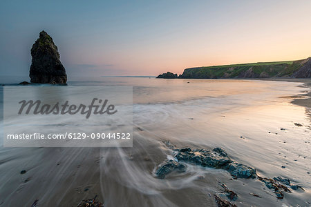 Ballydowane Cove, County Waterford, Munster province, Ireland, Europe. The sea stack in the ocean with the high tide. Ballydowane Cove, County Waterford, Munster province, Ireland, Europe. The sea stack in the ocean with the high tide.
