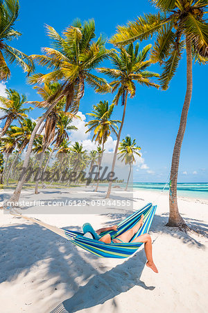 Canto de la Playa, Saona Island, East National Park (Parque Nacional del Este), Dominican Republic, Caribbean Sea. Woman relaxing on a hammock on the beach (MR). Canto de la Playa, Saona Island, East National Park (Parque Nacional del Este), Dominican Republic, Caribbean Sea. Woman relaxing on a hammock on the beach (MR).