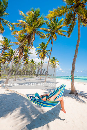 Canto de la Playa, Saona Island, East National Park (Parque Nacional del Este), Dominican Republic, Caribbean Sea. Woman relaxing on a hammock on the beach (MR).