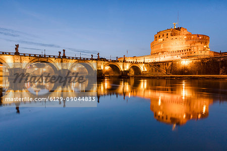 Dusk on the ancient palace of Castel Sant'Angelo with statues of angels on the bridge on Tiber RIver Rome Lazio Italy Europe