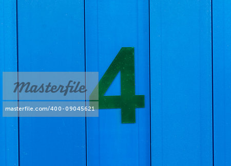 the number four green, set against bright blue wood