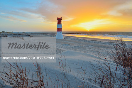 Beach with sand dunes and lighthouse at sunrise on Helgoland in the North Sea, Schleswig Holstein, Germany