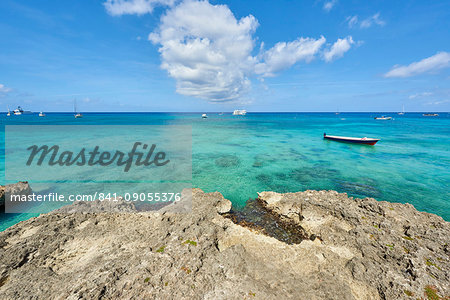 Rocky coastline in Cayman Islands with fishing boat in the transparent blue water, Cayman Islands, West Indies, Caribbean, Central America