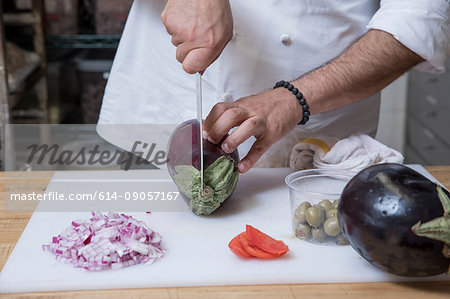 Cropped view of chef slicing aubergine