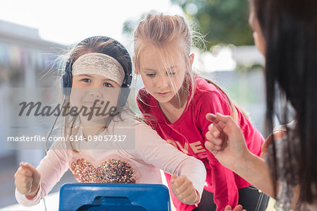 Young girl with friend, wearing headphones, dancing