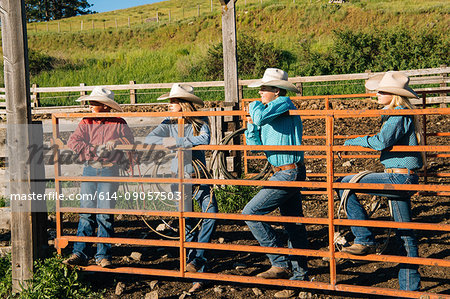 Cowboys and cowgirls leaning on gate, looking away, Enterprise, Oregon, United States, North America