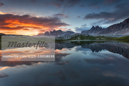 Dolomites, Italy. Clouds and colors at dawn are reflected at Laghi dei Piani, not far from Locatelli hut in Sesto Dolomites.