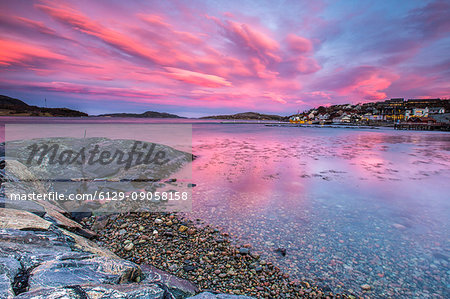 Pink sky at sunrise reflected in the cold waters Flatanger Trøndelag Norway Europe