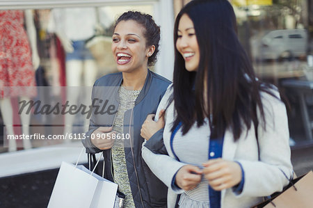 Smiling, happy young women with shopping bags