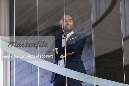Serious, CEO businessman standing at office window