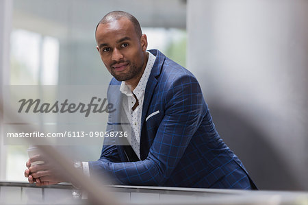 Portrait confident businessman leaning on railing