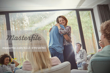Man and woman hugging in group therapy session