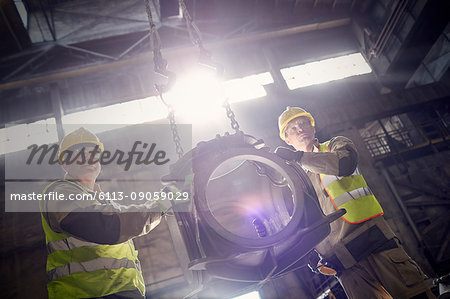 Steelworkers moving steel part in steel mill