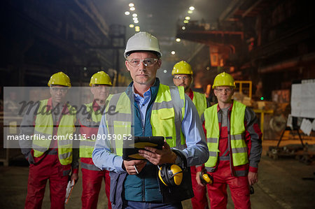 Portrait confident supervisor and steelworkers in steel mill