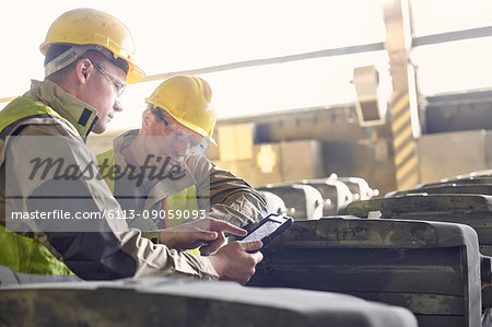 Steelworkers using digital tablet in steel mill