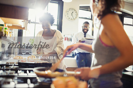 Friend roommates cooking breakfast in kitchen
