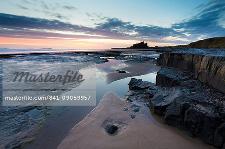 View towards Bamburgh Castle at sunrise from Bamburgh Beach, Bamburgh, Northumberland, England, United Kingdom, Europe View towards Bamburgh Castle at sunrise from Bamburgh Beach, Bamburgh, Northumberland, England, United Kingdom, Europe