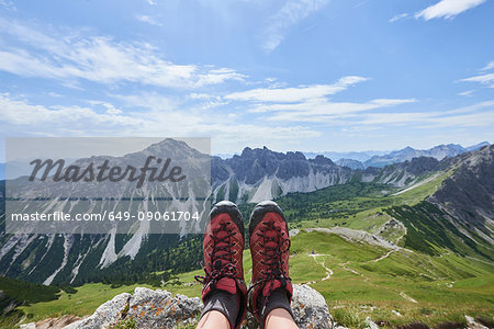 Personal perspective of female hiker's hiking boots over valley in Tannheim mountains, Tyrol, Austria