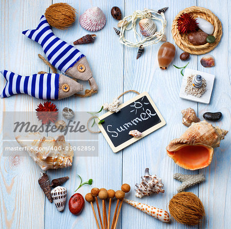 Summer Vacations Concept with Handmade Decorations, Various Shells, Dry Plants  and Chalk Board with Inscription Summer closeup on Light Blue Wooden background