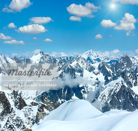 Mont Blanc mountain massif summer snowy sunshiny landscape with blue cloudy sky (view from Aiguille du Midi Mount, France)