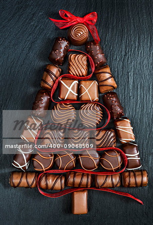 Chocolate  pralines Christmas tree on stone black table