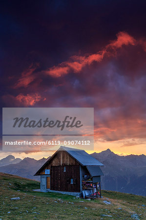 Wooden hut under fiery sky and clouds at sunset, Muottas Muragl, St. Moritz, Canton of Graubunden, Engadine, Switzerland, Europe