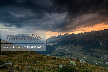 Dark clouds and sunset lights frame the rocky peaks of Muottas Muragl, St. Moritz, Canton of Graubunden, Engadine, Switzerland, Europe