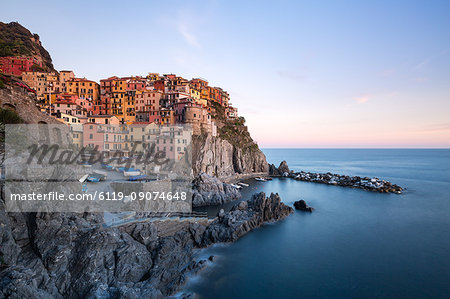 Beautiful sunset light shines on the colourful town of Manarola during a long exposure, Manarola, Cinque Terre, UNESCO World Heritage Site, Liguria, Italy, Europe