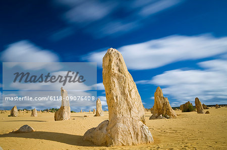 Desert landscape dotted with limestone pinnacles under a cloudy sky.