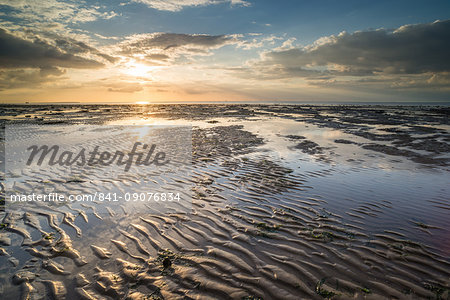 View of sandy beach and pools at low tide, at sunset, Reculver, Kent, England, United Kingdom, Europe