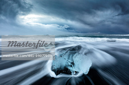 Glacier ice on black sand beach with waves washing up the beach on a stormy winter day, near Jokulsarlon, South Iceland, Polar Regions Glacier ice on black sand beach with waves washing up the beach on a stormy winter day, near Jokulsarlon, South Iceland, Polar Regions