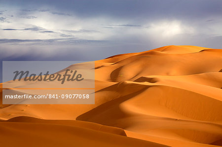 Orange sand dunes against stormy sky, Erg Chebbi sand sea, part of the Sahara Desert near Merzouga, Morocco, North Africa, Africa
