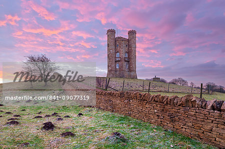 Broadway Tower and Cotswold drystone wall at sunrise, Broadway, Cotswolds, Worcestershire, England, United Kingdom, Europe