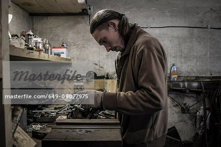 Mechanic working at workshop bench