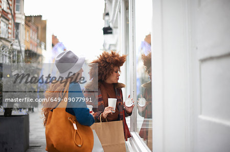 Two young women looking in shop window