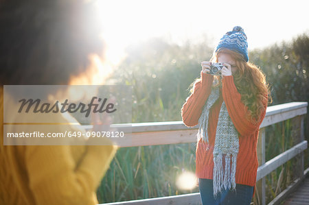 Woman photographing friends with digital camera