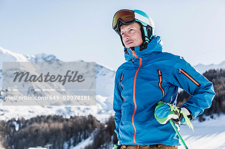 Portrait of skier on mountain, looking at view