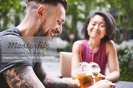Multi ethnic hipster couple at sidewalk cafe, Shanghai French Concession, Shanghai, China