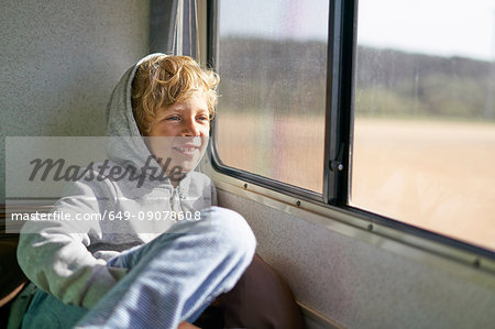 Boy sitting in campervan looking out of window, Polonio, Rocha, Uruguay, South America