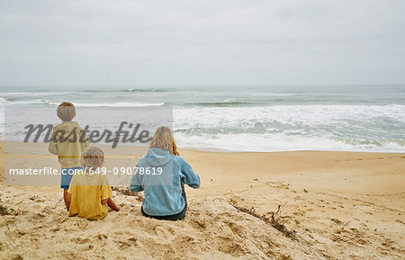 Family on beach looking away at sea, Florianopolis, Santa Catarina, Brazil, South America