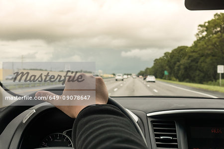 Man driving car on highway, Florida, USA, close up of hand and steering wheel