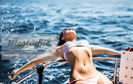 Woman in bikini enjoying sun and sea on boat