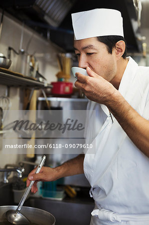 Chef working in the kitchen of a Japanese sushi restaurant, tasting food.