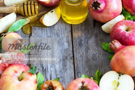 Apples, pomegranate and honey - symbols of judaic holiday Rosh Hashana (Jewish New Year). Selective focus. Copyspace background.