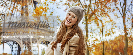 Autumn getaways in Paris. Portrait of happy young woman near Eiffel tower having fun time