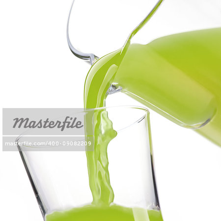 Pouring detox green vegetable and kiwi juice in a glass, healthy drinks concept