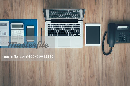 Flat lay business office desktop with laptop, tablet, smartphone and telephone