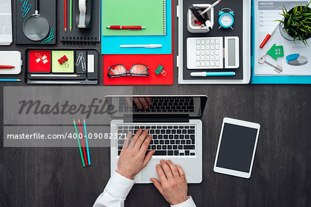Creative businessman working at office desk and using a laptop, technology and business concept